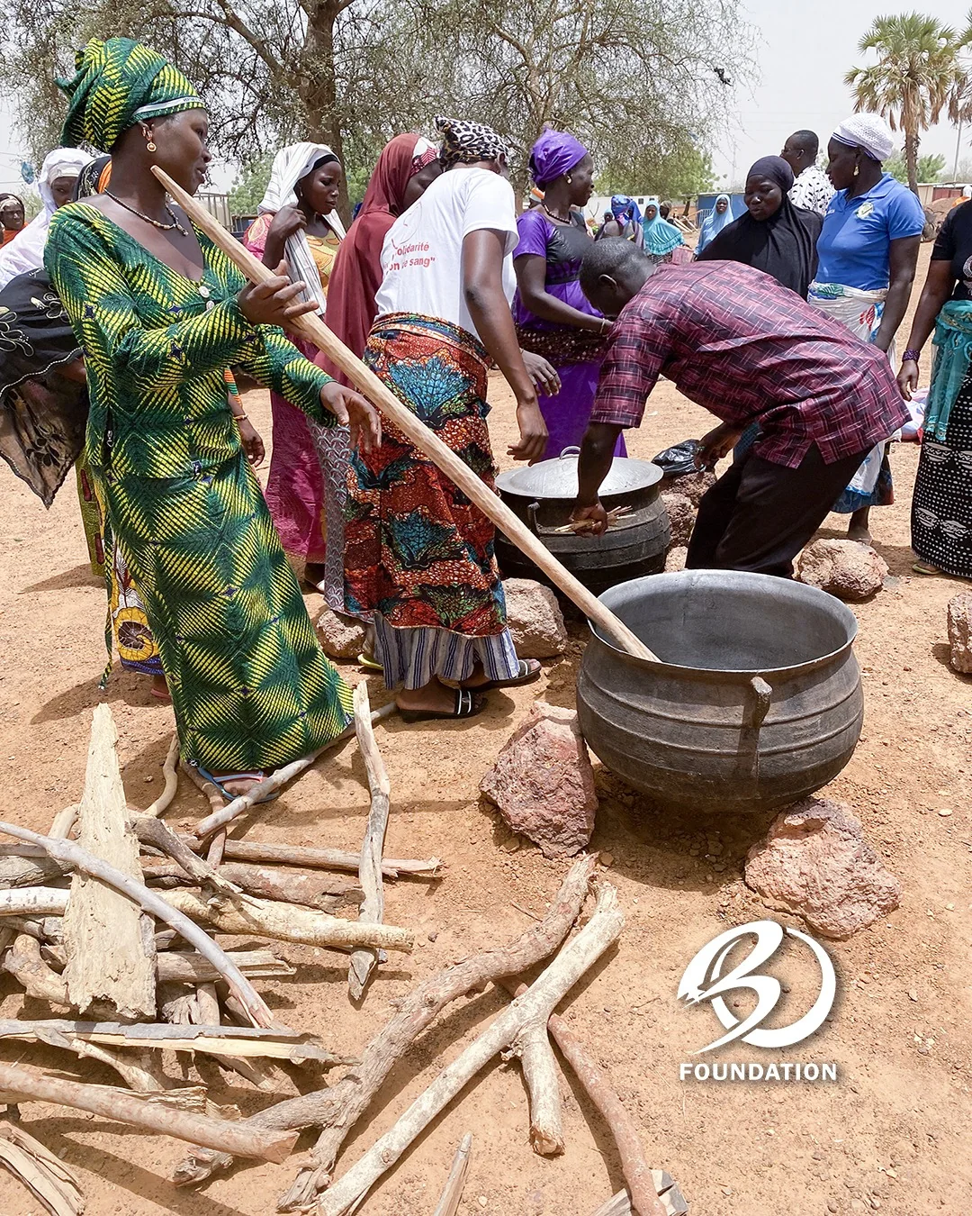 Community members sharing a moment around an outdoor cooking area in Kaya.
